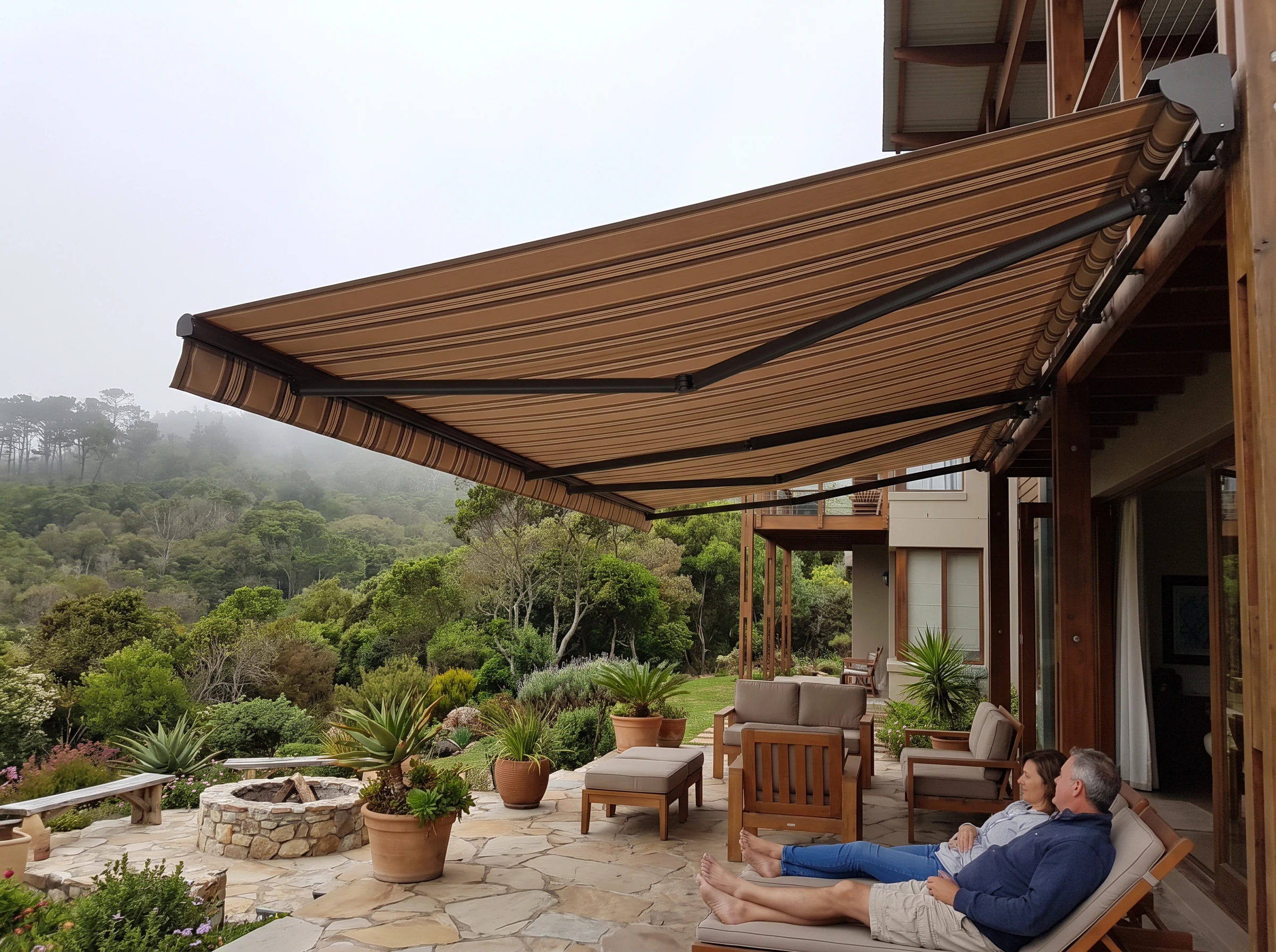 Folding-arm awning extended over a patio in a George home with forested hillside behind